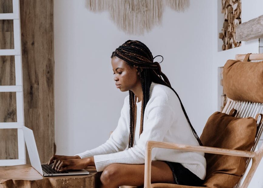 woman in white long sleeve shirt sitting on brown wooden chair